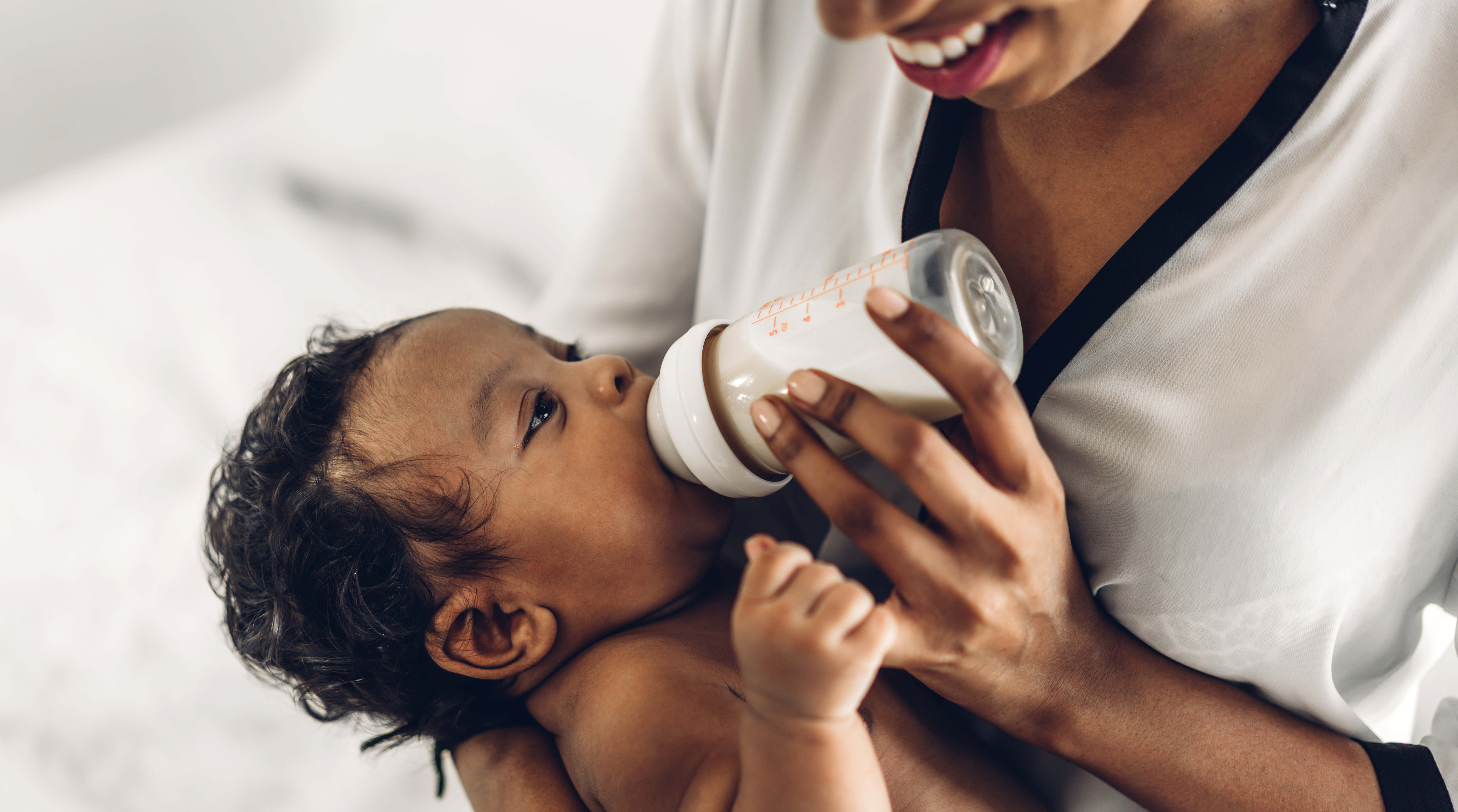 Moeder geeft baby een fles melk